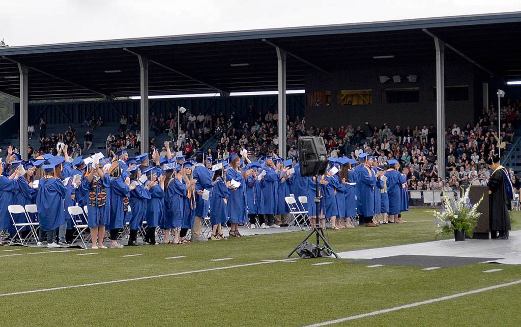 DAN HAMMOCK | THE DAILY WORLD                                Graduating Grays Harbor College students wave to their friends and families packed into the stands at Stewart Field on Friday. They did so after college president Dr. Jim Minkler said it was necessary to thank those who supported the students on their journey.