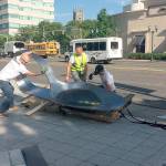 Artist Domenic Esposito, in yellow vest, and Stamford art gallery owner Fernando Luis Alvarez, at right, oversee the installation of an 800-pound, 10 1/2 feet long bent, burnt heroin spoon, in front of the headquarters of Purdue Pharma in Stamford at about 8:30 a.m. Friday, June 22, 2018. The unauthorized installation was a protest against Purdues prominent role in the manufacture of opioids. The spoon was removed about two hours later, after Alvarez was arrested on two criminal counts. (Susan Dunne/Hartford Courant)