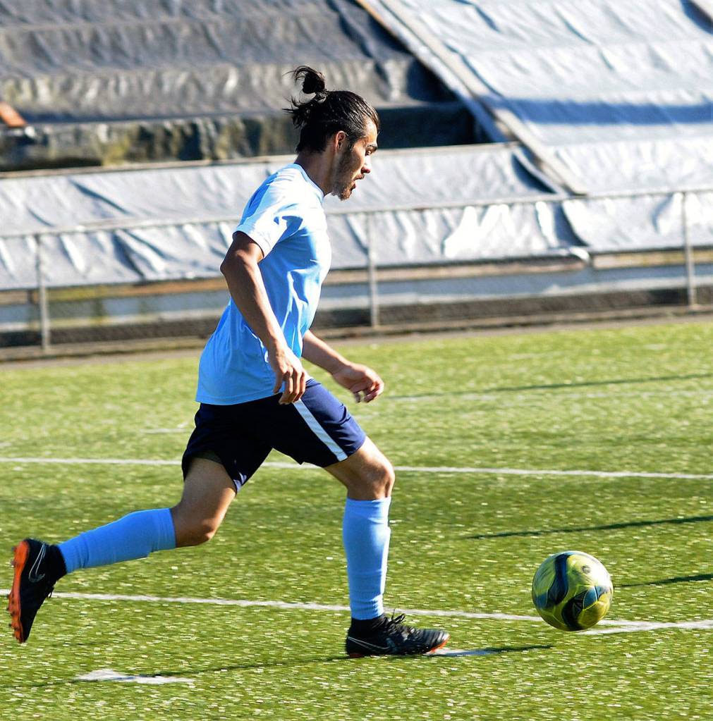 Gulls defender Victor Corona dribbles the ball away from his own goal against Issaquah on June 16. Corona played midfield in high school but was converted to centerback at the start of the season. (Hasani Grayson | The Daily World)