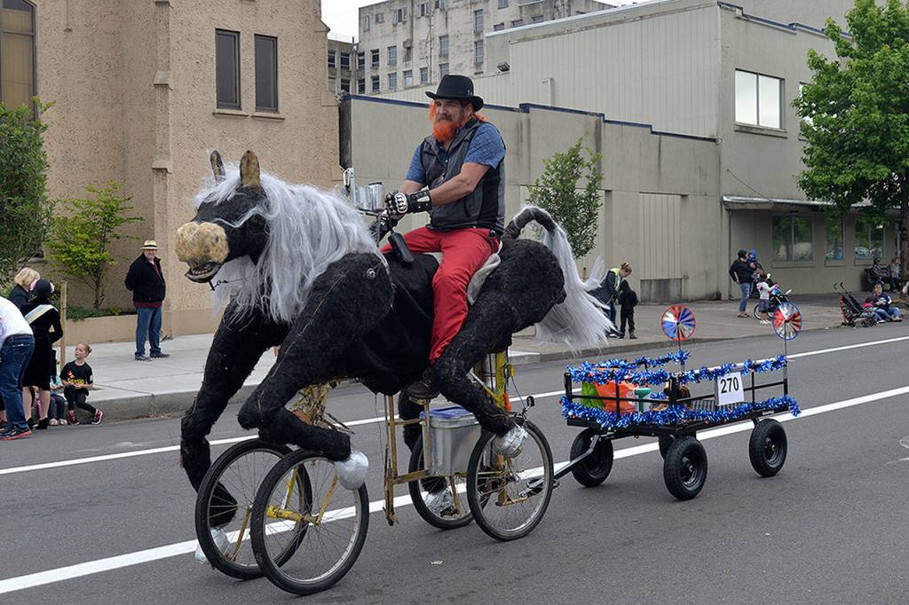 LOUIS KRAUSS | THE DAILY WORLD John Culp rides his self-made horse bicycle through the Founders Day Parade in Aberdeen.