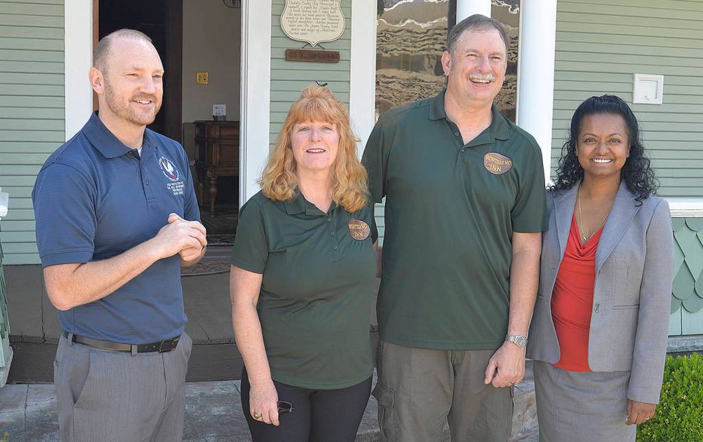A visitor checks out a painting over the living fireplace during a tour of the Montesano Inn bed and breakfast. Above him are hand-painted Bavarian murals.                                Montesano Inn owners Pam and John Lansing.