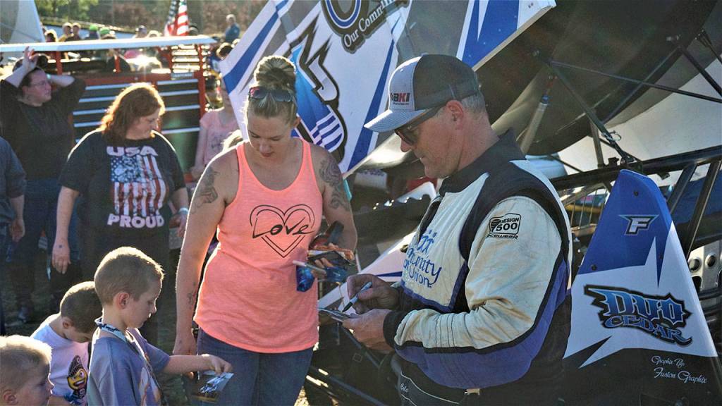 Sprint car winner Jay Cole, right, signs autographs for fans during Grays Harbor Raceways Fan Appreciation festivities on Saturday. (Photo by AR Racing Videos)