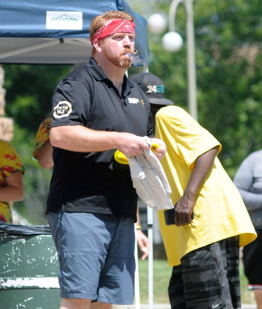 Orion Desilets measure his throw at the Bubba Mullikin Memorial Disc Golf Tournament. (Hasani Garyson | The Daily World)