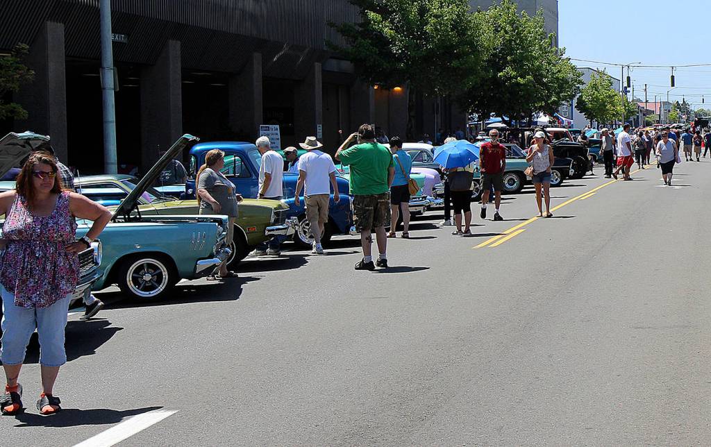 DAN HAMMOCK | THE DAILY WORLD                                A small sample of the hundreds of cars and the hundreds of people checking them out at the Midnight Cruizers annual Aberdeen car show July 14. The elaborate paint jobs on many of them shown brightly on the warm, clear day.