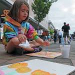 File photo                                Teagan Youmans of Hoquiam paints a tile during the 2012 ArtWalk in downtown Aberdeen. Tile painting will once again be available in the Kids Corner at this years event.