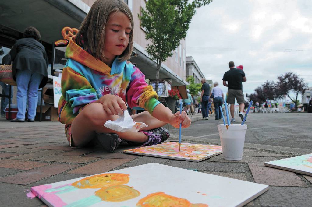 File photo                                Teagan Youmans of Hoquiam paints a tile during the 2012 ArtWalk in downtown Aberdeen. Tile painting will once again be available in the Kids Corner at this years event.