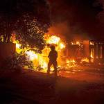 Three firefighters hose down a structure on Ridge Drive to slow the spread of fire to other structures during the Carr Fire on Thursday in Redding, Calif. (Daniel Kim/Sacramento Bee/TNS)