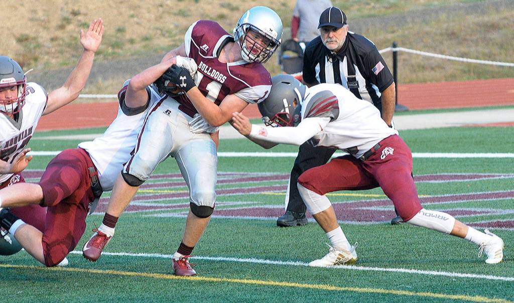 Levi Suddeerth, left and Antonio Garcia, right combine to tackle Brent Hollatz at the Jamboree on Friday, Aug. 24.(Hasani Grayson | The Daily World)