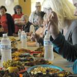 Louis Krauss | The Daily World                                Isaak McDonald, right, tries out the food at Thursdays United Way kickoff party that featured a cooking. McDonald was one of four judges.