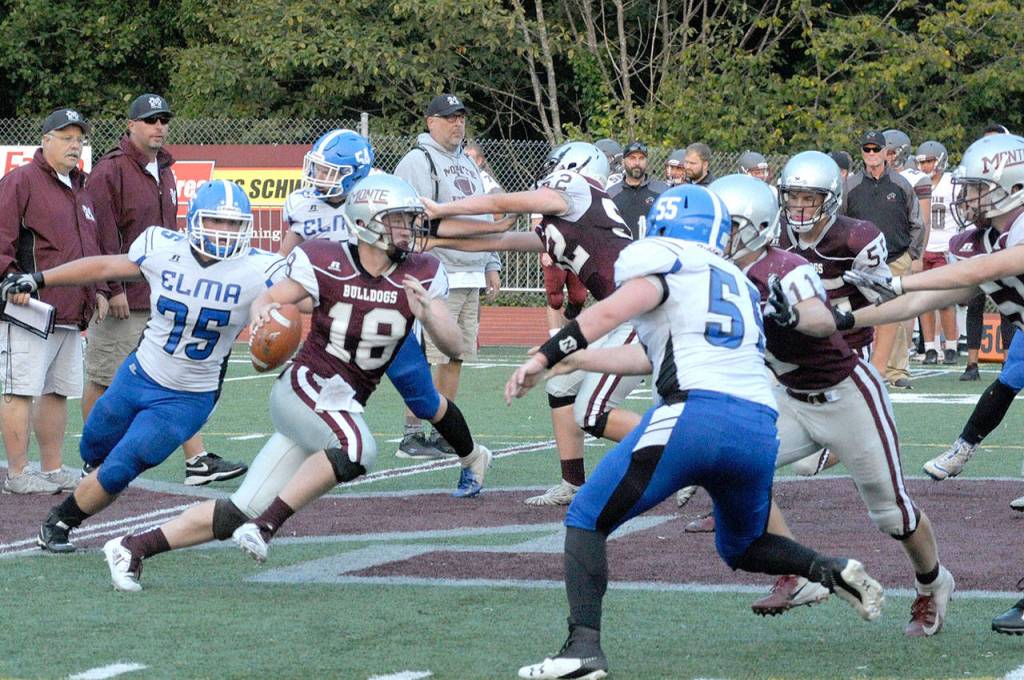Montesanos Shaydon Farmer avoids tackles from Elmas Blake Foster (55) and Jacob Garcia (75) before throwing the ball downfield at the jamboree on Friday. (Hasani Grayson | The Daily World)