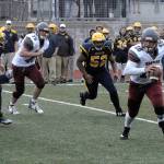 Hoquiam quarterback Payton Quintanilla rolls to the outside while being pursued by the Aberdeen defense during the jamboree on Friday at Montesano High School. (Hasani Grayson | The Daily World)
