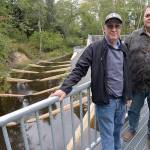 DAN HAMMOCK | THE DAILY WORLD                                Cosmopolis mayor Frank Chestnut (left) and city administrator Darrin Raines stand atop the walkway along the new Mill Creek Dam. Behind them is the fish ladder constructed to allow the return of steelhead and chum and coho salmon.