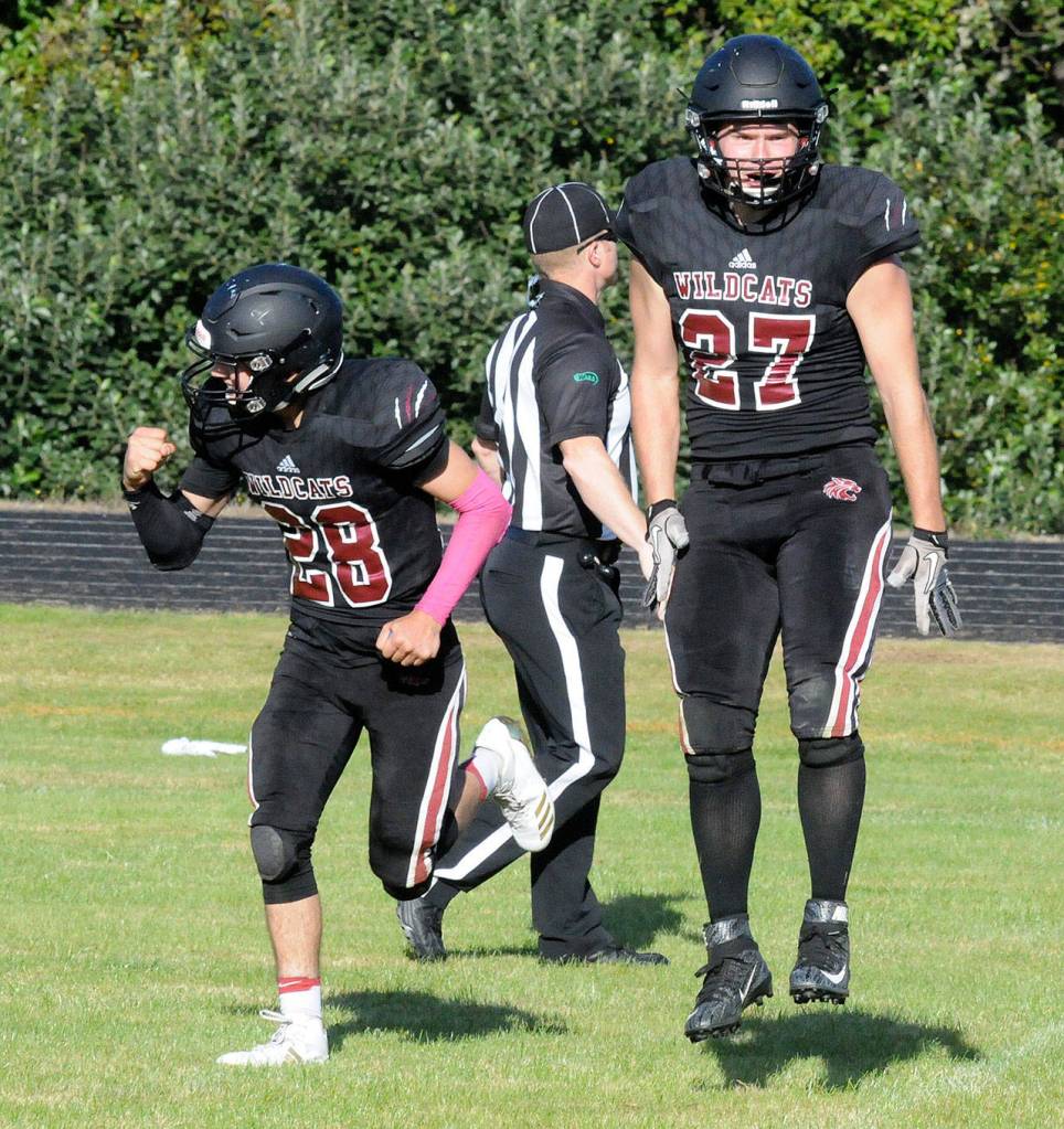 Ocostas Kobe Beck, left, and Paul Bjornsgard celebrate a victory after the final whistle blew in the Wildcats 14-7 victory on Saturday in Westport. (Ryan Sparks | The Daily World)