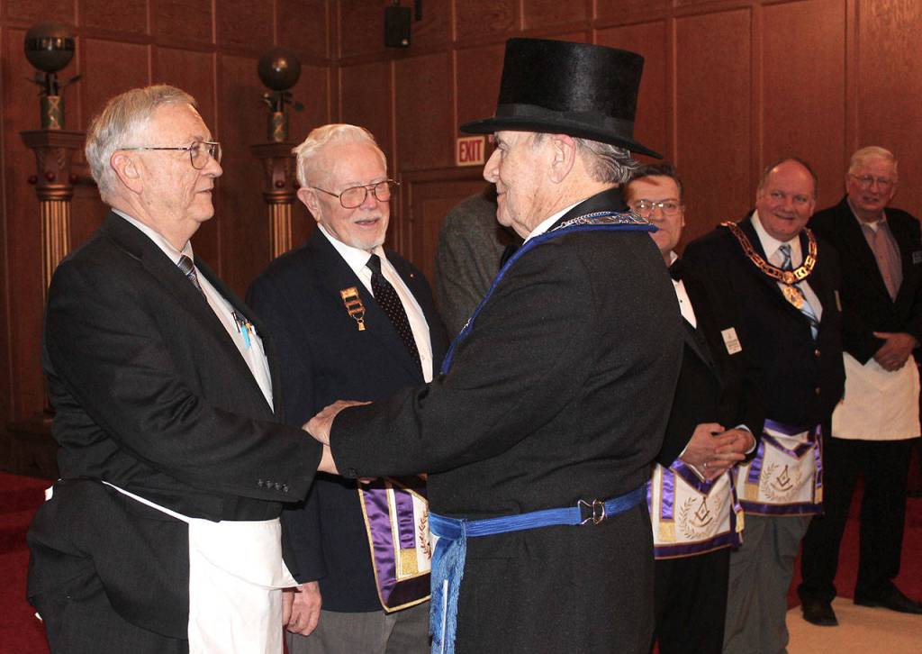 As master of Wynooche 43, Free and Accepted Masons of Washington, Walt Twidwell is the only member allowed to wear a hat inside the lodge at Montesano. After being installed as master last Christmas, Twidwell thanked North River neighbor Jim Banas, left. At center is Sherman Richmond of Ocean Park, past master of the Ilwaco Masons lodge. (Photo by Patrick Webb)