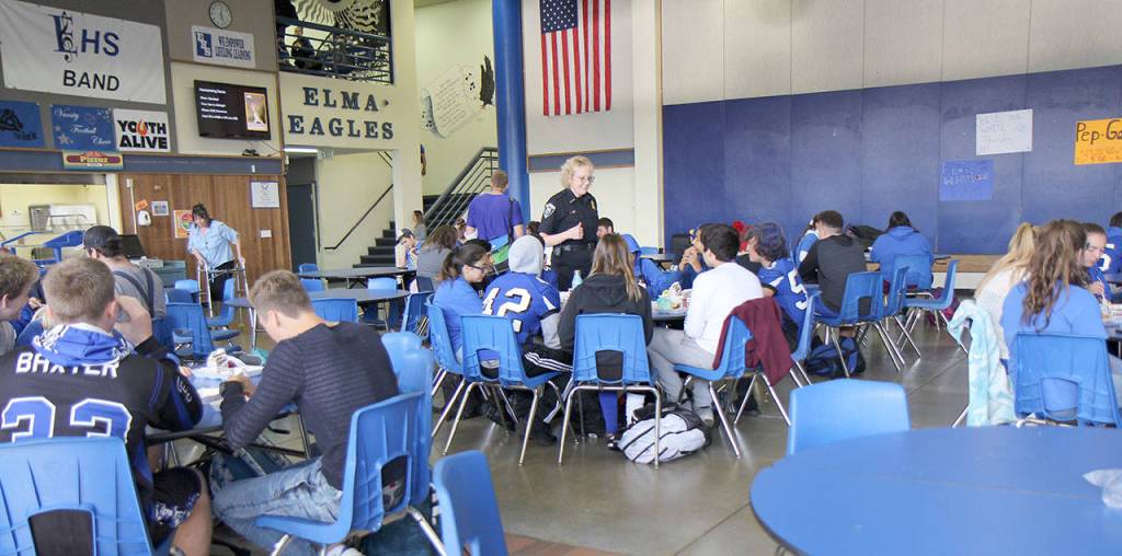 Elma Police Chief Susan Shultz (standing at center) chats with high-schoolers during lunch Thursday, Oct. 4, at Elma High School in Elma. I want them to see our department engaging with them in a positive manner and being a familiar face in school. Seeing law enforcement on campus for the positive moments as well as those where bad choices or mistakes have been made, she said. Photo by Michael Lang, Grays Harbor News Group