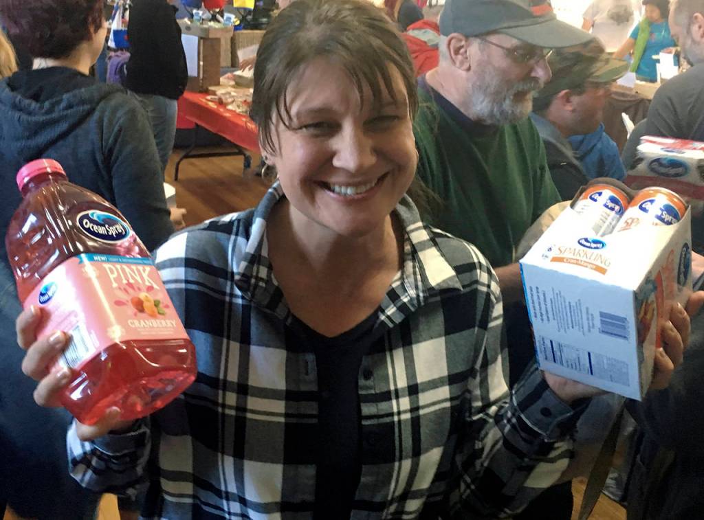 (Kat Bryant | Grays Harbor News Group) Michelle Corey, co-winner of the adult division in the cranberry eating contest, shows off her prizes, donated by Ocean Spray.