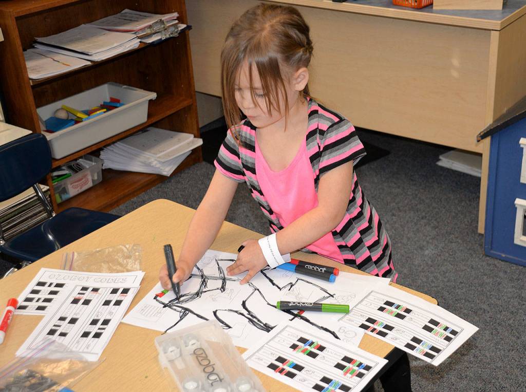 Louis Krauss | The Daily World                                A student at Robert Gray Elementary draws a line for her robot to follow.