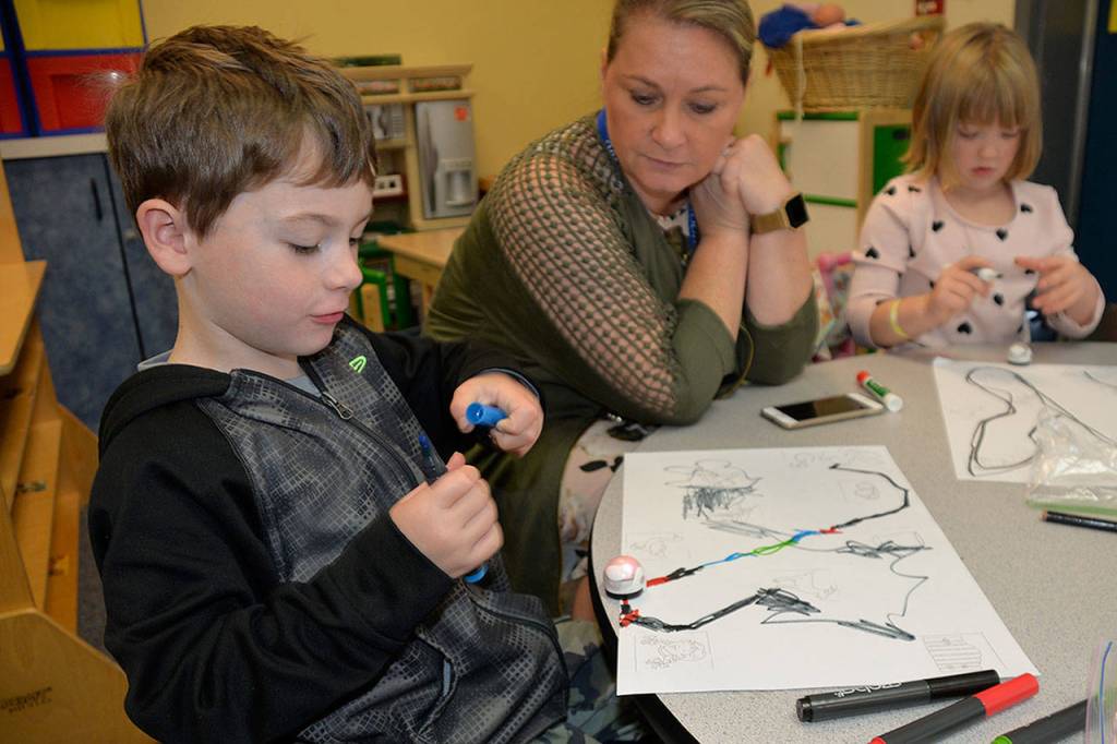 Louis Krauss | The Daily World                                A student uses markers to make a code for his robot to speed up.