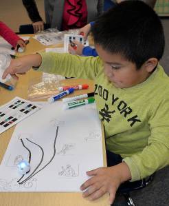 Louis Krauss | The Daily World                                A kindergarten student watches as his Ozobot robot follows the line he drew.