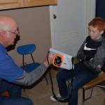 Louis Krauss | The Daily World                                Lions Club member Erv Granahan, left shows a Stevens Elementary student the vision screener report after scanning his eyes with it.