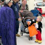 Ila Myers hands candy to a little Mickey Mouse. She and her husband, Mike, of Cosmopolis, adorned their Ford Mustang with webbing and spiders.