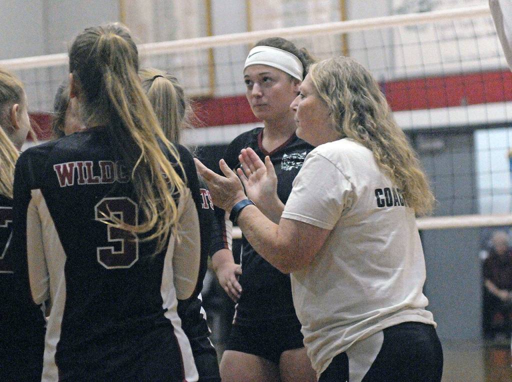 Pacific league co-MVP Kaylee Barnum, background, huddles with her Ocosta teammates and head coach Barbara Rasmus, right, who was honored as the leagues Coach of the Year for leading the Wildcats to a league title and undefeated regular season. (Hasani Grayson | Grays Harbor News Group)