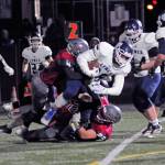 Lynden Christian receiver Zach Sipma is tackled by Hoquiams Levi Sudderth (4) and Matt Brown (29) during the Lyncs 45-6 victory in a state quarterfinal playoff game on Saturday at Stewart Field. (Ryan Sparks | Grays Harbor News Group)