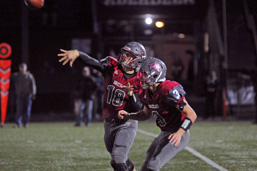 Hoquiam quarterback Payton Quintanilla, left, throws while protected by Antonio Garcia during the first quarter of the Grizzlies playoff loss on Saturday. Quintanilla, the reigning 1A Evergreen League MVP, left the game in the second quarter after a right ankle injury suffered late in the week was reaggravated. (Ryan Sparks | Grays Harbor News Group)