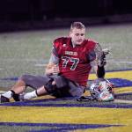 Hoquiam lineman Zack Underwood removes his helmet, gloves and cleats and leaves them at midfield, signifying the seniors last prep football game after the Grizzlies 45-6 loss to Lynden Christian in a 1A State Football Quarterfinal playoff game Saturday at Stewart Field. (Ryan Sparks | Grays Harbor News Group)