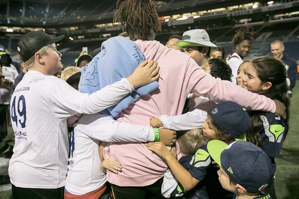 Seattle Seahawks linebacker Shaquem Griffin meets with a group of kids from NubAbility, a non-profit for kids with limb loss to get into mainstream sports after a game against the Oakland Raiders at CenturyLink Field in Seattle on August 30, 2018. (Bettina Hansen/Seattle Times)