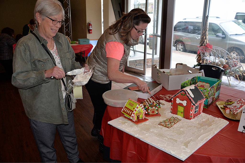 (Louis Krauss | The Daily World) Aberdeen Parks Director Stacie Barnum, right, and her mom Cheryl Konn lay out their gingerbread town.
