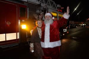 (Louis Krauss | Grays Harbor News Group)                                Santa poses with Bette Worth after emerging from a firetruck.