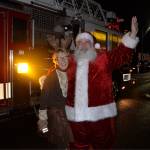 (Louis Krauss | Grays Harbor News Group)                                Santa poses with Bette Worth after emerging from a firetruck.