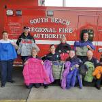 COURTESY PHOTO                                South Beach firefighters were able to purchase more than 100 winter coats by participating in Operation Warm, a program where participants get deep discounts to donate coats to children within the community.