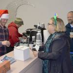 DAN HAMMOCK | GRAYS HARBOR NEWS GROUP                                Complete with Santa hat, Hoquiam Business Associations Kyle Pauley serves up cocoa for the Cocoa Stroll and maps and ballots for the Festival of Trees at the 7th Street Theatres business office Saturday evening. Folks who voted for their favorite trees in local businesses got a free commemorative 2018 Ho Ho Hoquiam ornament when they turned in their ballots.