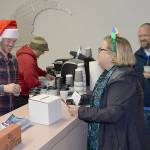 DAN HAMMOCK | GRAYS HARBOR NEWS GROUP                                Complete with Santa hat, Hoquiam Business Associations Kyle Pauley serves up cocoa for the Cocoa Stroll and maps and ballots for the Festival of Trees at the 7th Street Theatres business office Saturday evening. Folks who voted for their favorite trees in local businesses got a free commemorative 2018 Ho Ho Hoquiam ornament when they turned in their ballots.