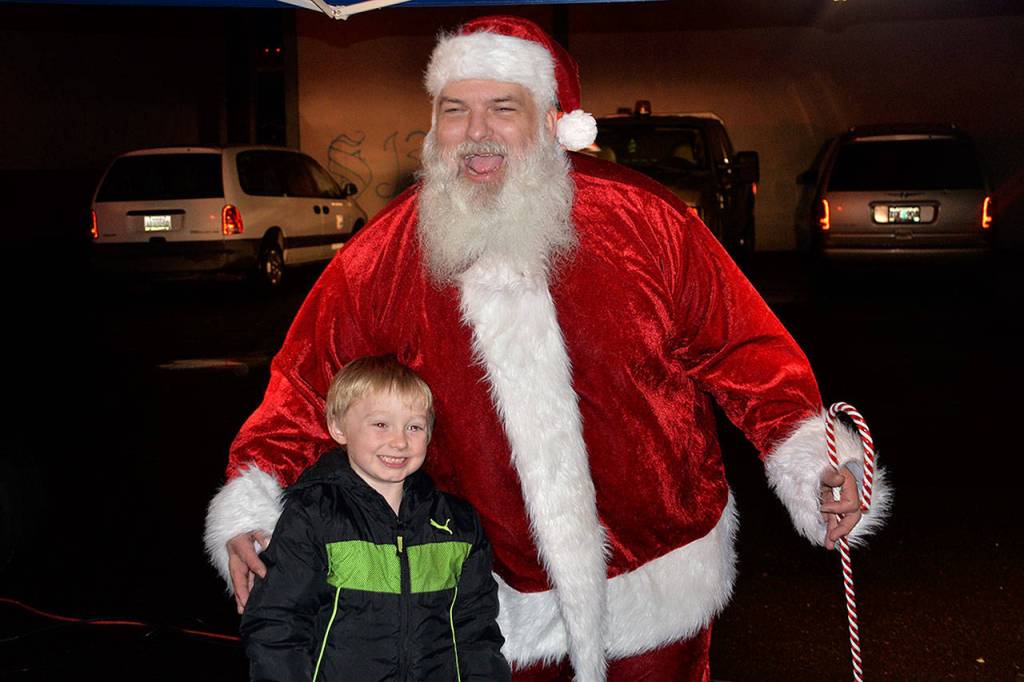 (Louis Krauss | Grays Harbor News Group)                                Ryan Housden poses with Santa at Zelasko Park in Aberdeen on Friday.