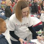 Grays Harbor County Prosecuting Attorney Katie Svoboda works the wrapping station at Walmart during the Shop with a Cop event Saturday. Participating kids got $100 to spend on whatever they wanted, and could have their gift items wrapped before leaving the store.
