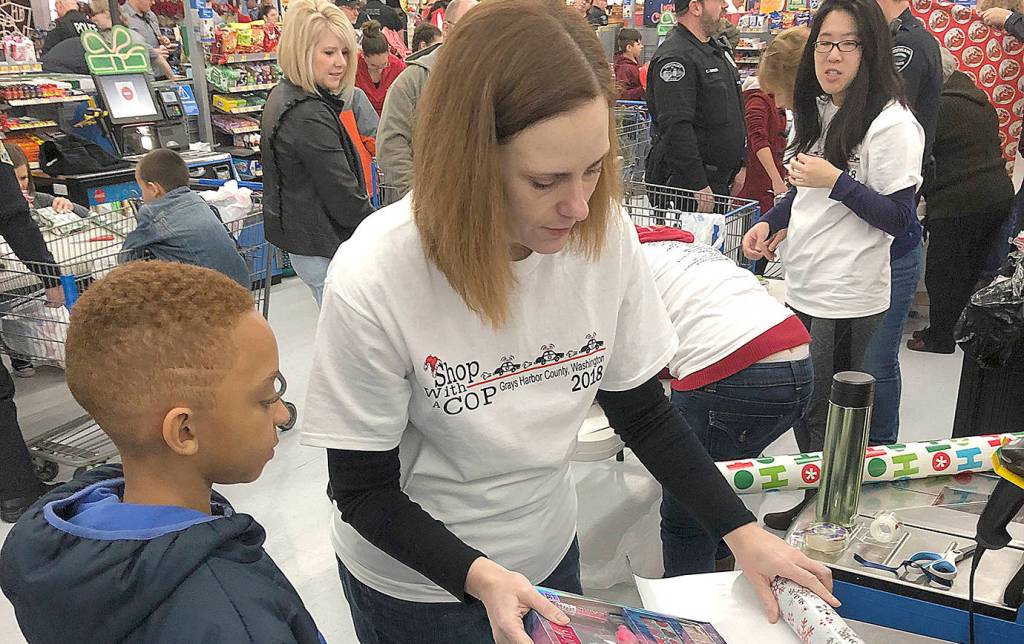 Grays Harbor County Prosecuting Attorney Katie Svoboda works the wrapping station at Walmart during the Shop with a Cop event Saturday. Participating kids got $100 to spend on whatever they wanted, and could have their gift items wrapped before leaving the store.