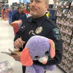 Ocean Shores Police officer Chris Iversen lugs a colorful stuffed animal through Walmart Saturday morning.