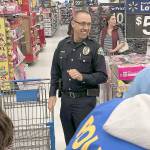 Aberdeen Police Chief Steve Shumate watches the participants of the 2018 Shop with a Cop event invade Walmart Saturday morning.