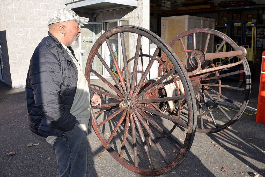 Louis Krauss | Grays Harbor News Group                                Aberdeen Museum of History director Dave Morris inspects the damaged wheels of another antique fire cart in Kent last week.