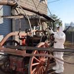 (Louis Krauss | Grays Harbor News Group)                                An employee for Restoration Management Company uses a scraper to clean the Old Tiger fire cart from the Aberdeen Museum of History.