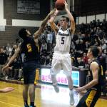 Montesanos Evan Bates, middle, hits a shot while defended by Javier Bojorge in the fourth quarter of a game on Friday. (Hasani Grayson | Grays Harbor News Group)