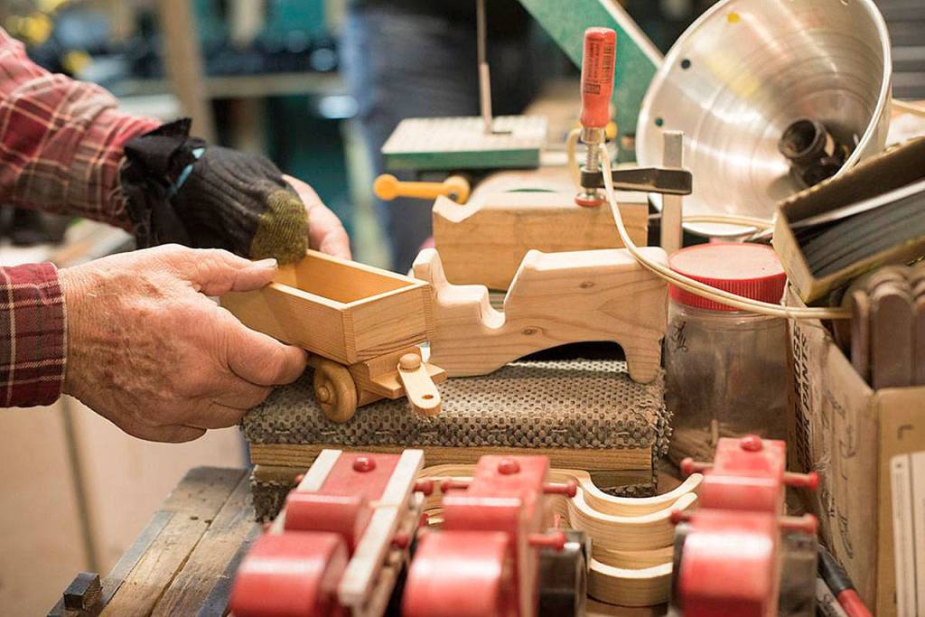 Don Powell holds a toy tractor that he was in the porcess of constructing last week in his Oakville shop (Katie Hayes | The Chronicle)