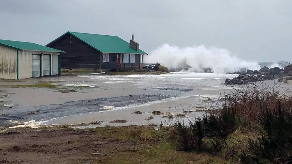(Marcy Merrill) The sea reaches for the last house standing on the point at North Cove.