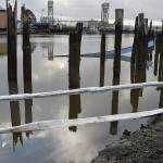 Louis Krauss | Grays Harbor News Group                                A boat sank into the Hoquiam River on Christmas morning, resulting in spilled oil that created a sheen over the water. Floating absorbents were deployed by the Washington State Department of Ecology.