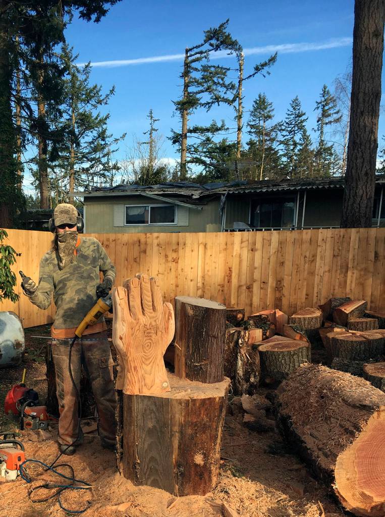 KAT BRYANT | GRAYS HARBOR NEWS GROUP                                The chainsaw artist known only as Thor is from Mossyrock, but was visiting Tony Robinson in Copalis Crossing when the call went out for this event. He carved a variety of images at the request of local residents, including these praying hands. Behind him is a neighbors home that was hit by a large tree during the December tornado.