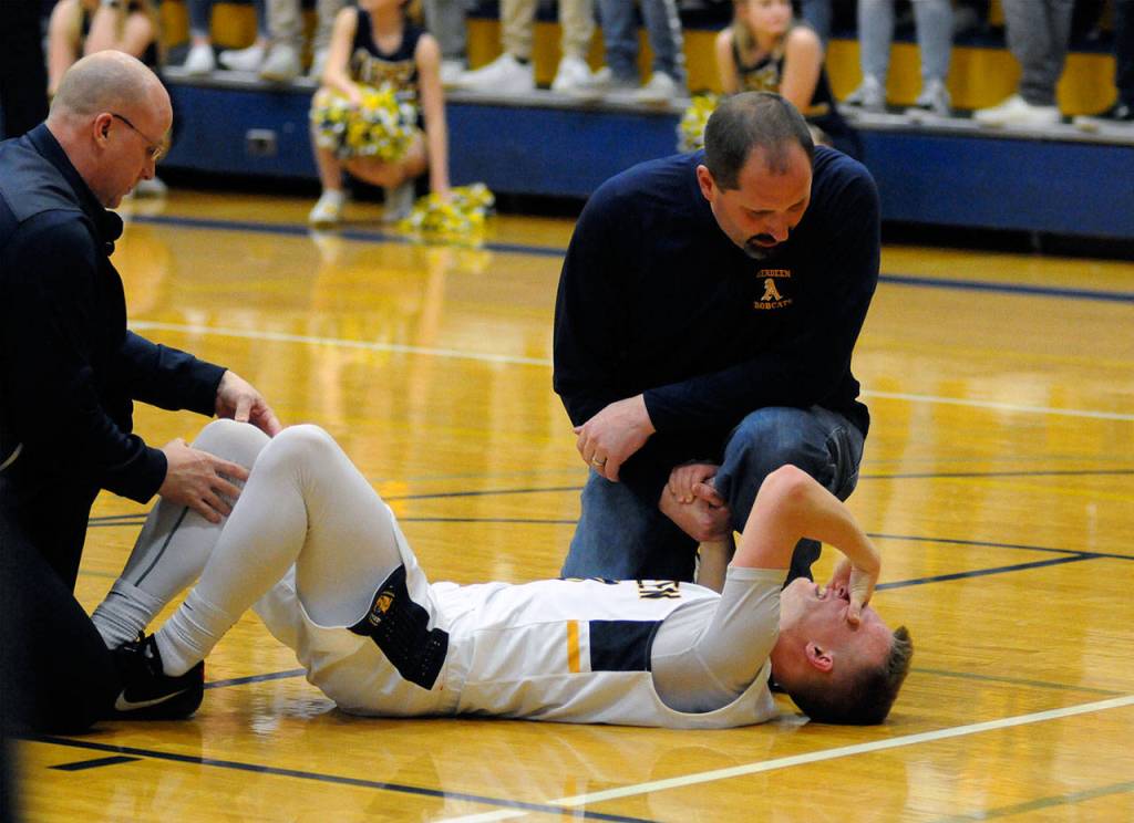 Aberdeen guard Ben Dublanko writhes in pain after suffering a knee injury during the fourth quarter of the Bobcats victory over Tumwater on Tuesday. Dublanko exited the game but returned after one possession. (Ryan Sparks | Grays Harbor News Group)