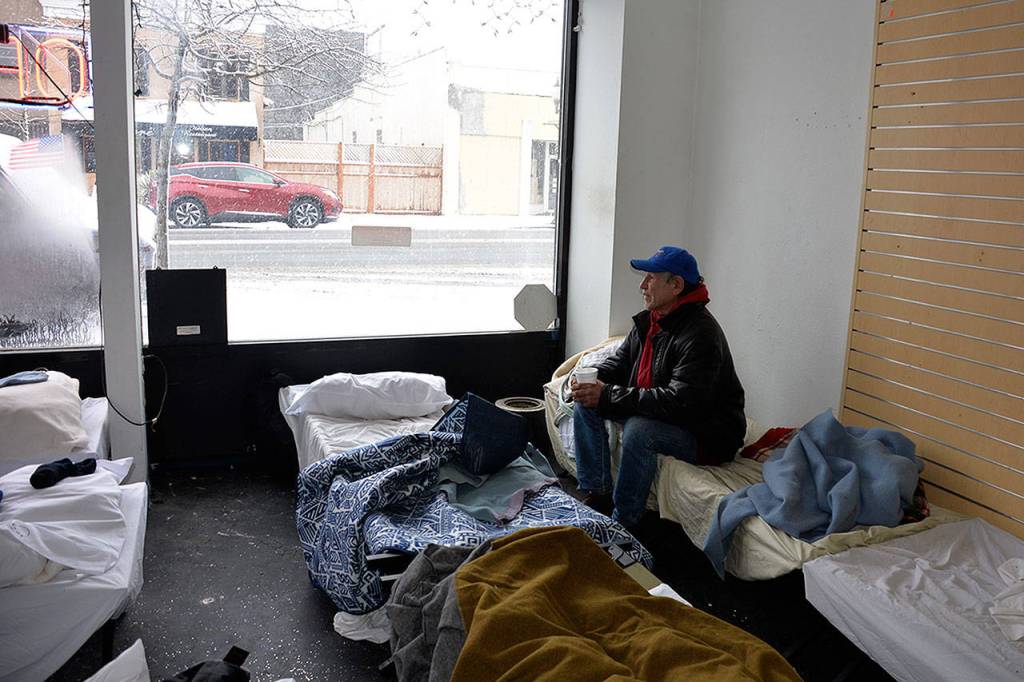 (Louis Krauss | Grays Harbor News Group) Jamie Mail sits on a cot at Revival of Grays Harbors cold weather shelter in Aberdeen Monday morning.